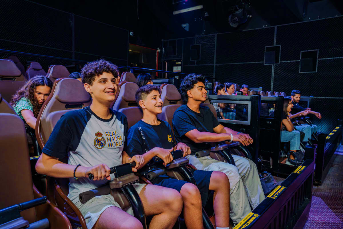 Children enjoying an interactive racing video game at Real Madrid World Dubai theme park attraction