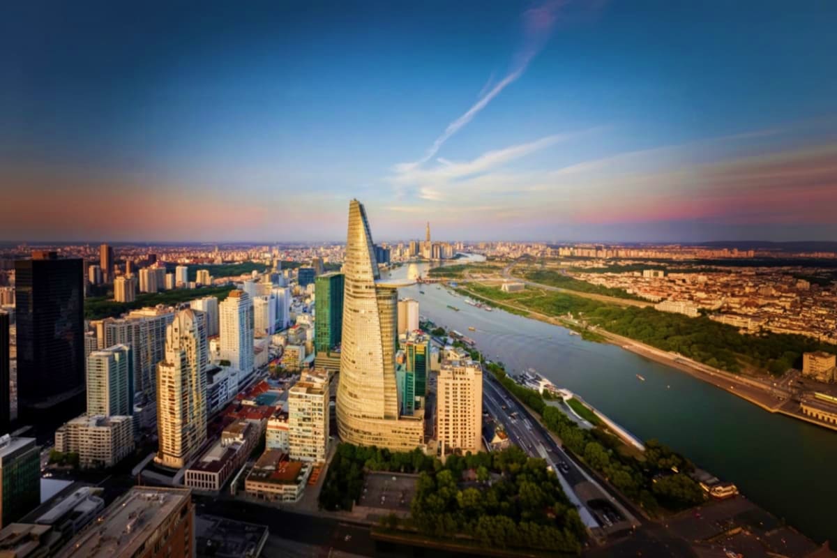 Aerial view of Bitexco Financial Tower and Ho Chi Minh City skyline with Saigon River at sunset