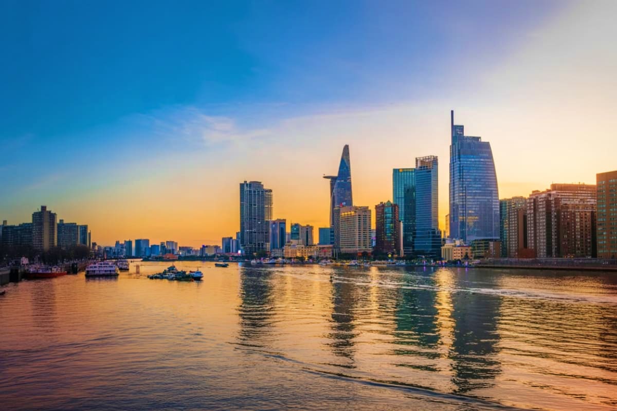 Ho Chi Minh City skyline at sunset with Bitexco Financial Tower and modern skyscrapers reflected in the Saigon River