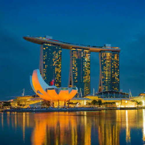 Guided Singapore Layover City Tour Marina Bay Sands hotel and ArtScience Museum illuminated at night reflected in water, Singapore skyline