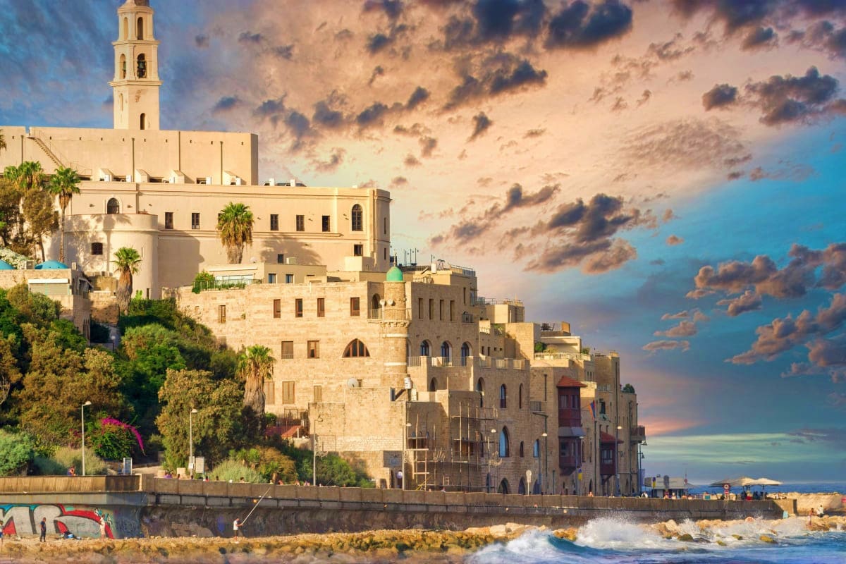 Israel Visa Historic old city buildings and mosque with tall minaret overlooking Mediterranean Sea beach in Jaffa, Israel
