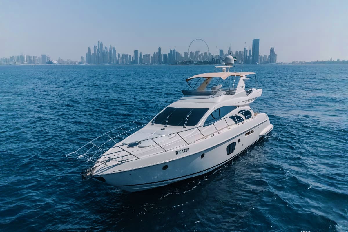 White 55-foot luxury yacht anchored in blue water with Manhattan skyline and Ferris wheel in background