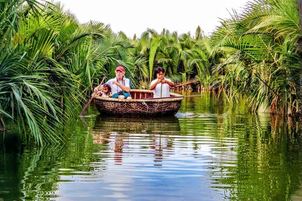 Family boating through lush palm trees and waterways in Vietnam's Mekong Delta region