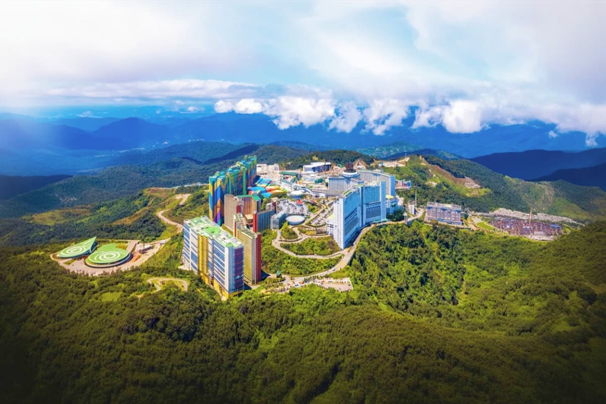 Singapore Malaysia Family tour Aerial view of a large integrated resort with colorful high-rise hotels, water park, and recreational facilities nestled in f