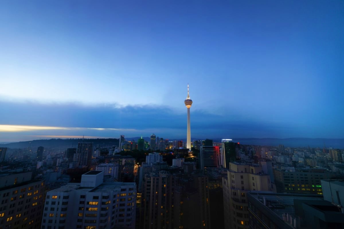 Dusseldorf cityscape at dusk with TV tower illuminated against blue sky and apartment buildings below