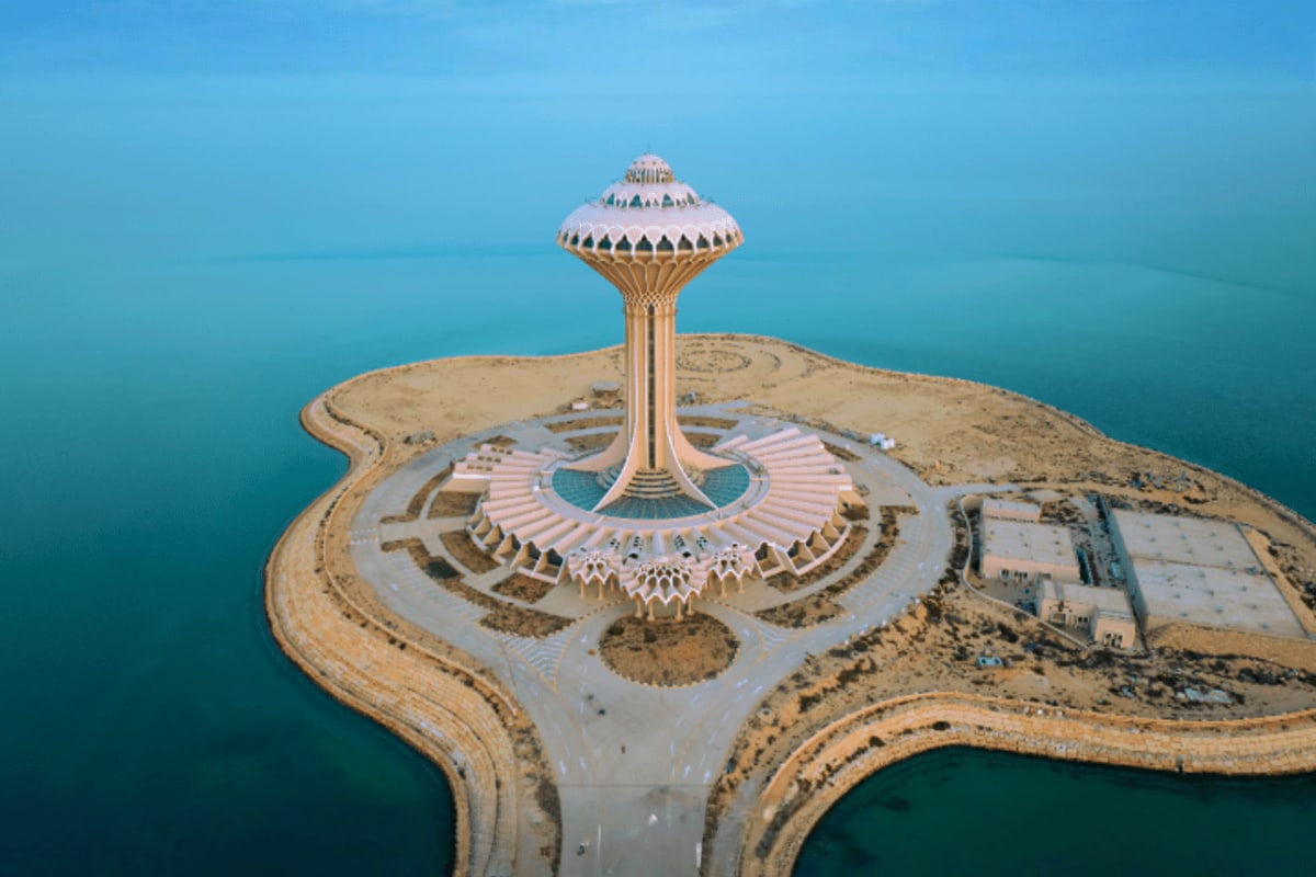 Aerial view of King Fahd's Fountain on an island in turquoise waters, Saudi Arabia's iconic landmark with white dome structur