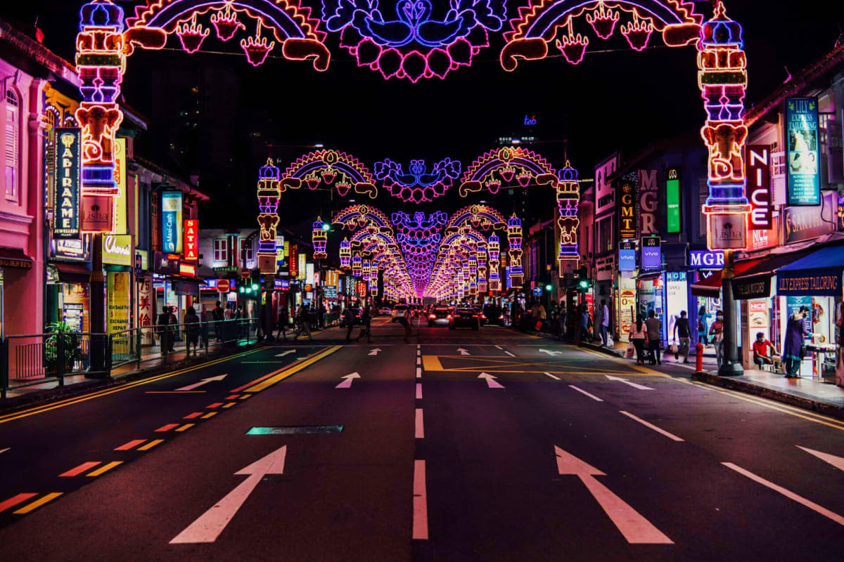Exclusive Singapore and sentosa tour Orchard Road in Singapore at night illuminated with colorful neon decorative arches and festive lights, lined with shops and