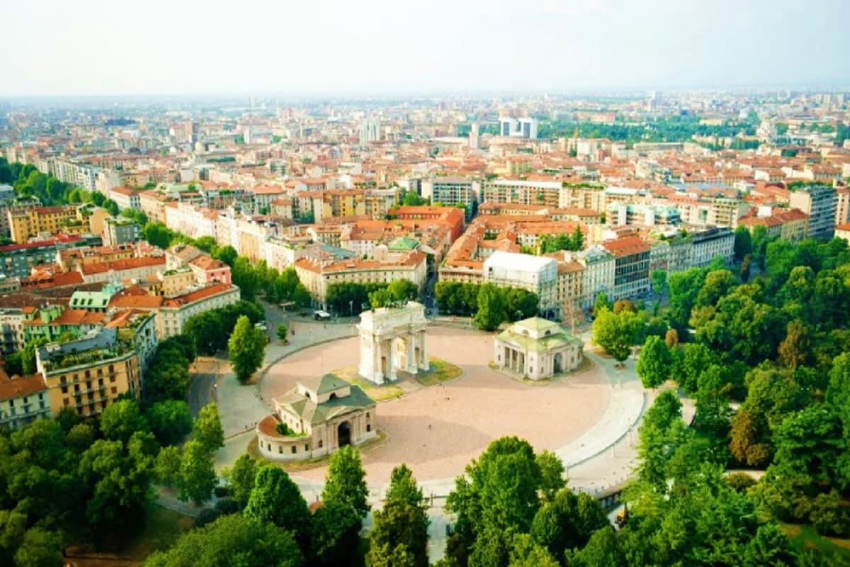 Aerial view of Milan's Arch of Peace monument surrounded by tree-lined park and historic cityscape in Italy