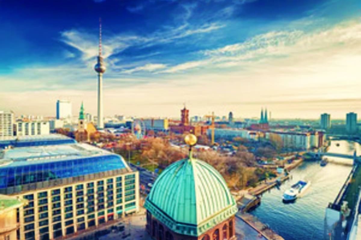 Aerial view of Berlin skyline featuring the iconic TV Tower, green-domed cathedral, Spree River, and historic architecture un