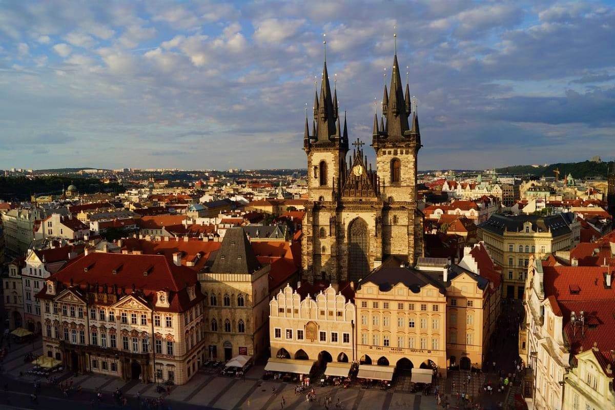 Church of Our Lady before Tyn with twin spires overlooking Old Town Square in Prague with historic buildings and red-tiled ro