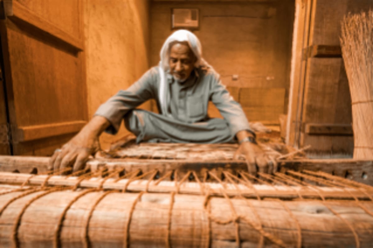 Craftsman demonstrating traditional wooden boat building in Dammam's heritage workshop