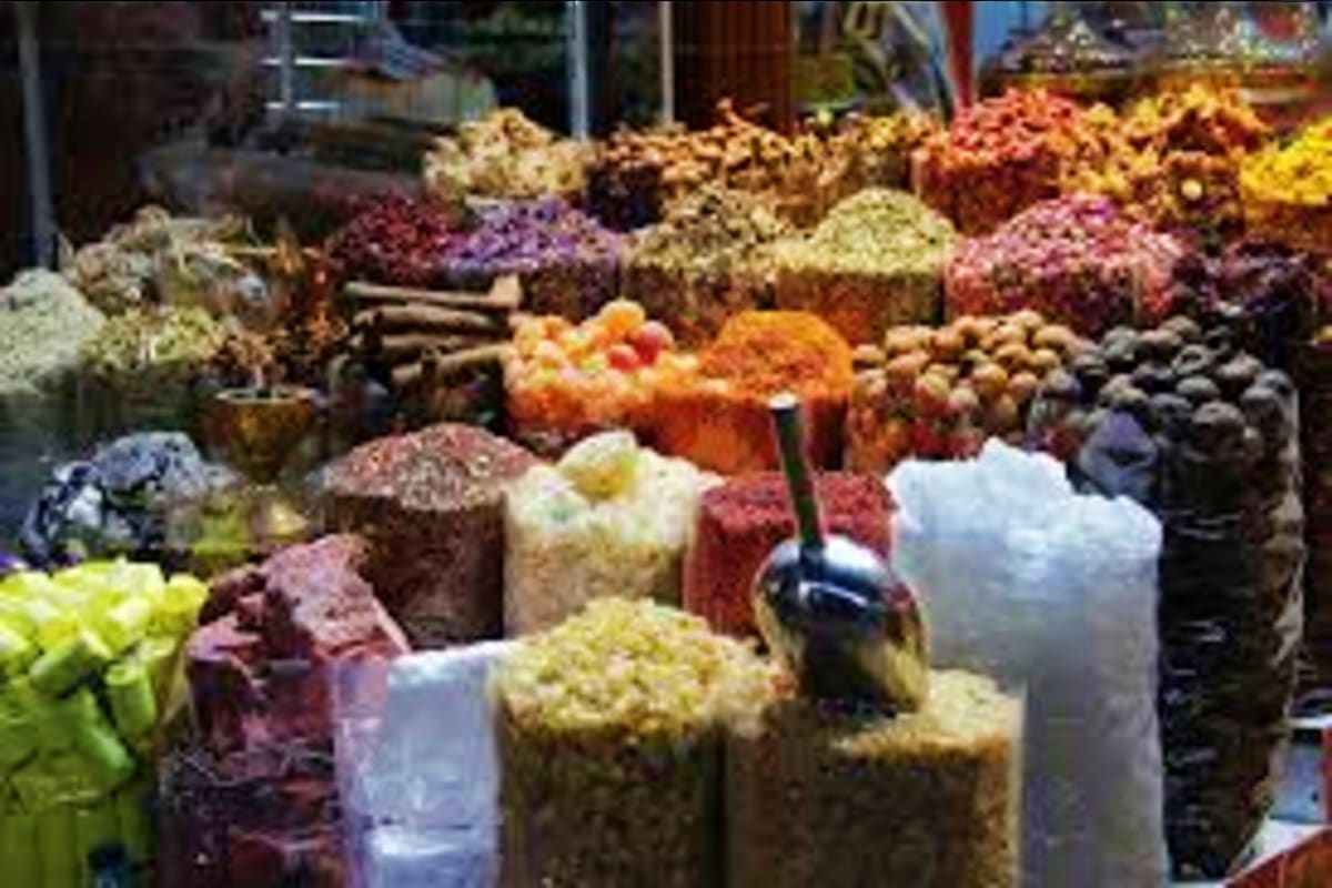 Colorful spice market display with vibrant piles of ground spices, powders, and herbs in various colors including red, yellow