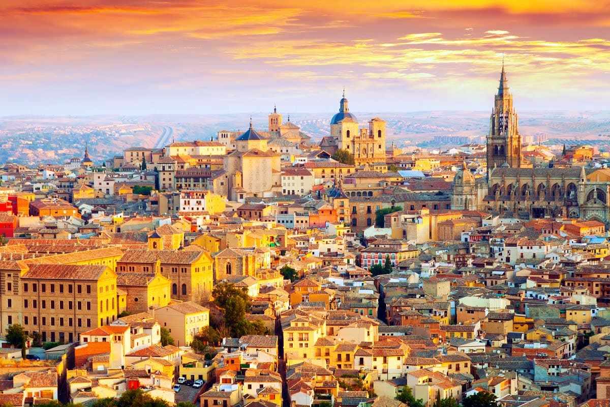 Segovia cityscape at sunset with historic cathedral and golden-hour light illuminating medieval architecture and terracotta r