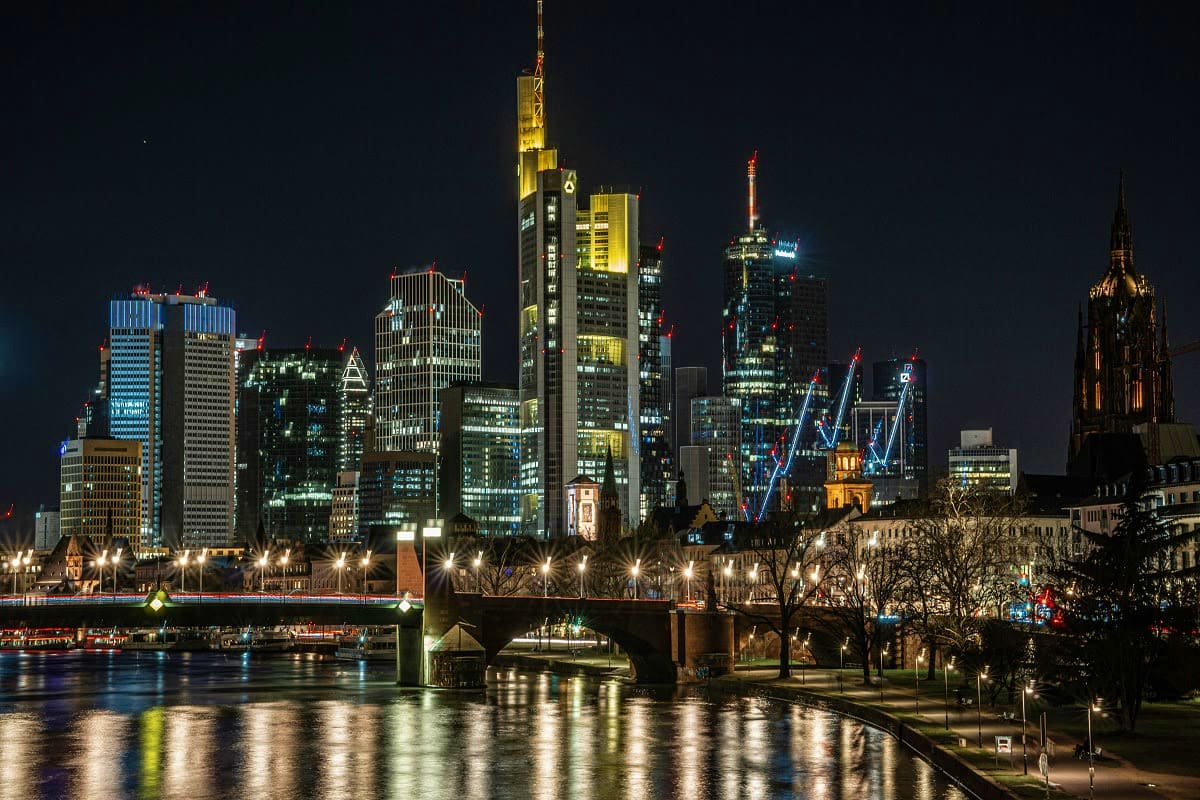 From Prague to Paris Frankfurt skyline illuminated at night with river and bridge reflection, European city architecture