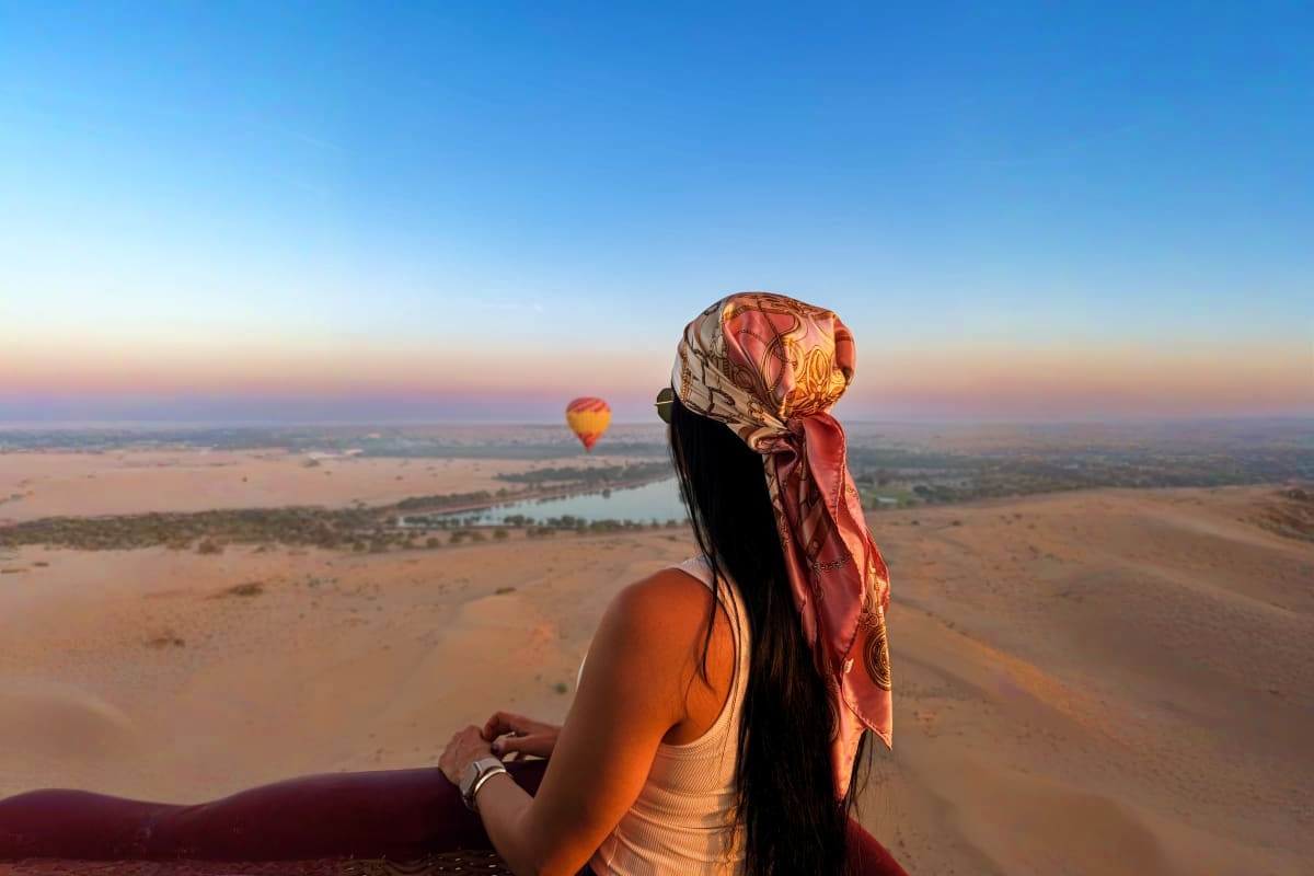 Family watching colorful hot air balloon being inflated on beach at sunrise in Dubai desert (4)