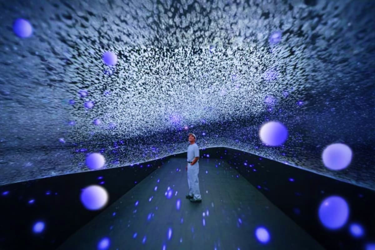 Space and Time Cube Thailand Person standing in immersive digital tunnel with purple glowing particles and data streams surrounding them in Space and Time