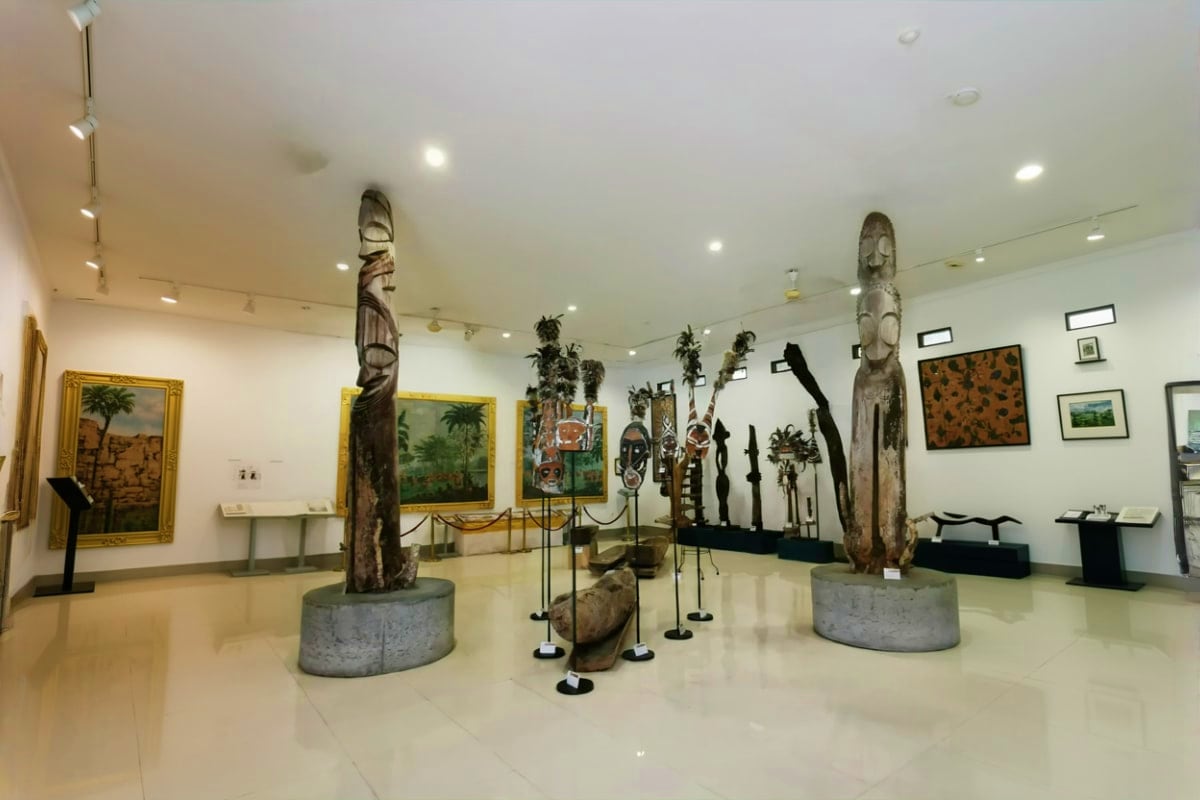 Museum Pasifika Bali Museum Pasifika Bali interior with carved wooden totems, framed paintings, and Pacific artifacts displayed in a modern galler