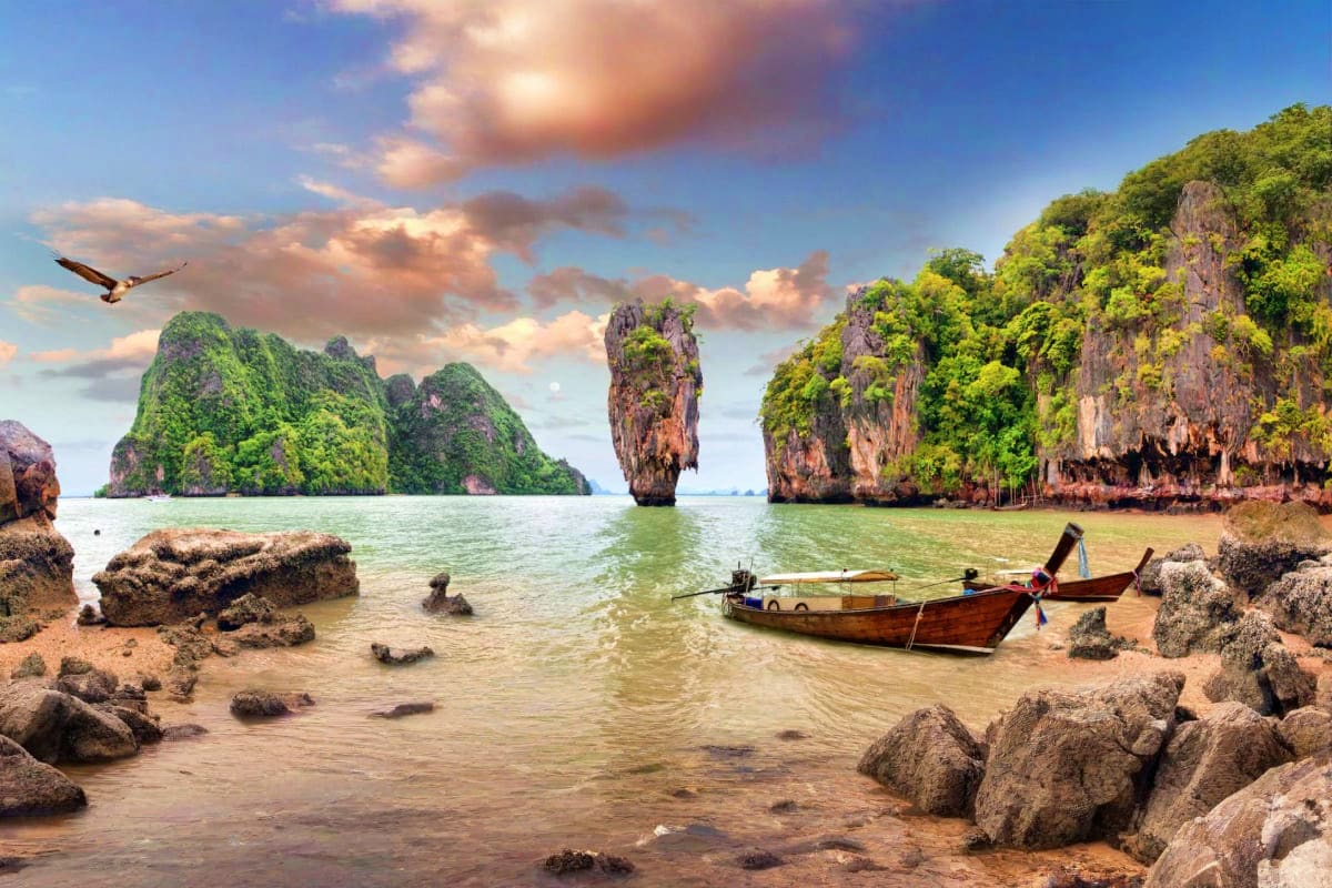 James Bond Island on Long Tail Boat Traditional long-tail boat anchored near limestone cliffs and James Bond Island in Phang Nga Bay, Thailand