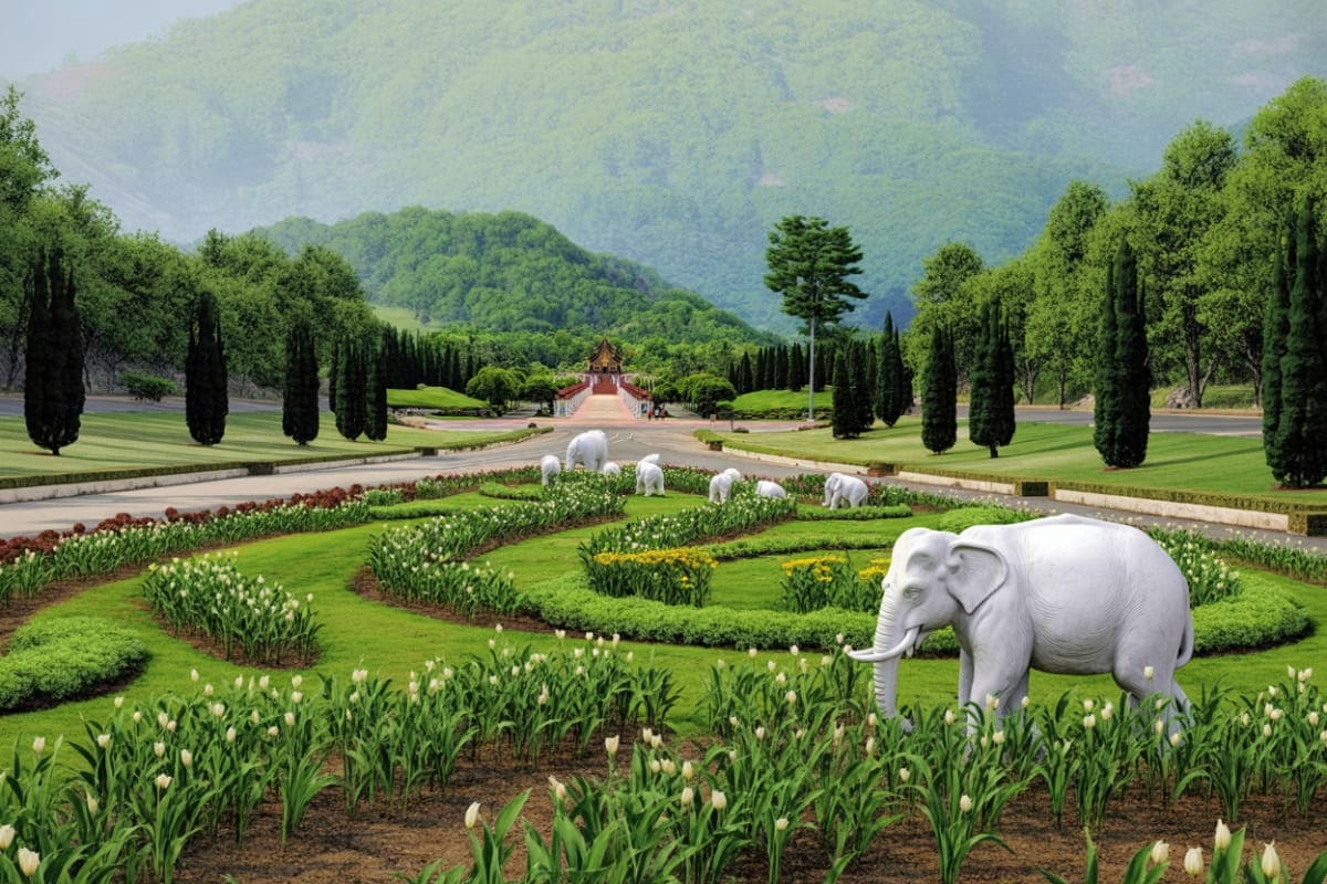 White elephants grazing in formal gardens with tulips, cypress trees, and traditional Thai temple in distant background at Ro