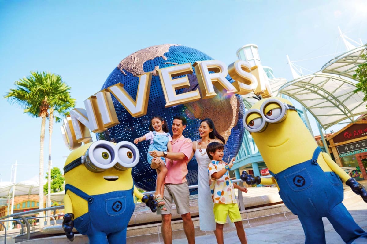 Universal Studios Singapore Family posing with Minion characters in front of Universal Studios Singapore globe landmark sign