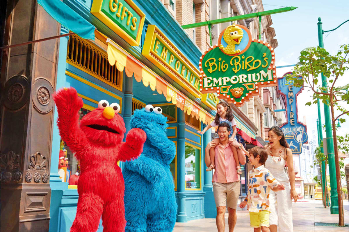 Universal Studios Singapore Family posing with Elmo and Cookie Monster characters outside Big Bird's Emporium at Universal Studios Singapore theme park