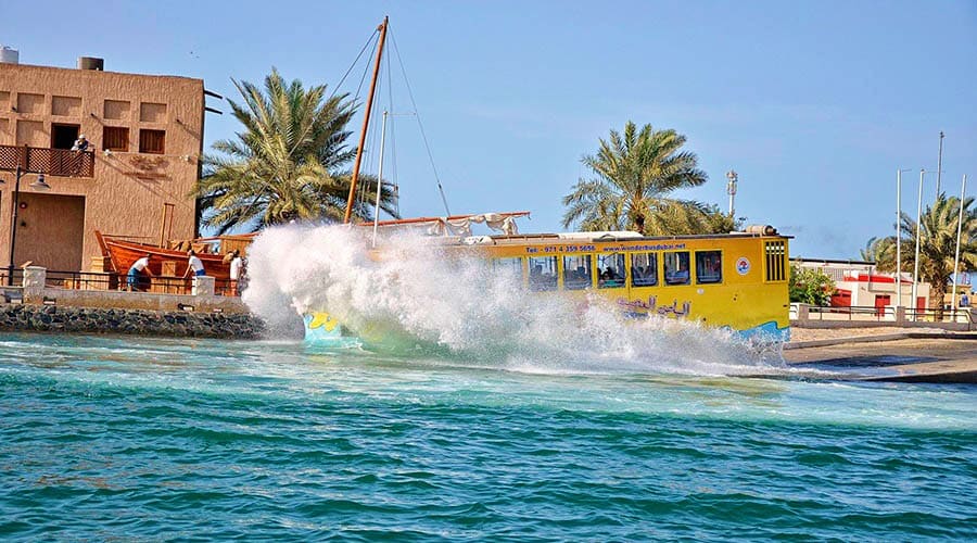 Yellow amphibious Wonder Bus with blue whale design driving into water during Dubai tour (4)