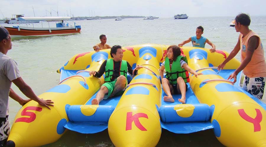 Family enjoying banana boat ride on blue water with yellow inflatable tube (5)
