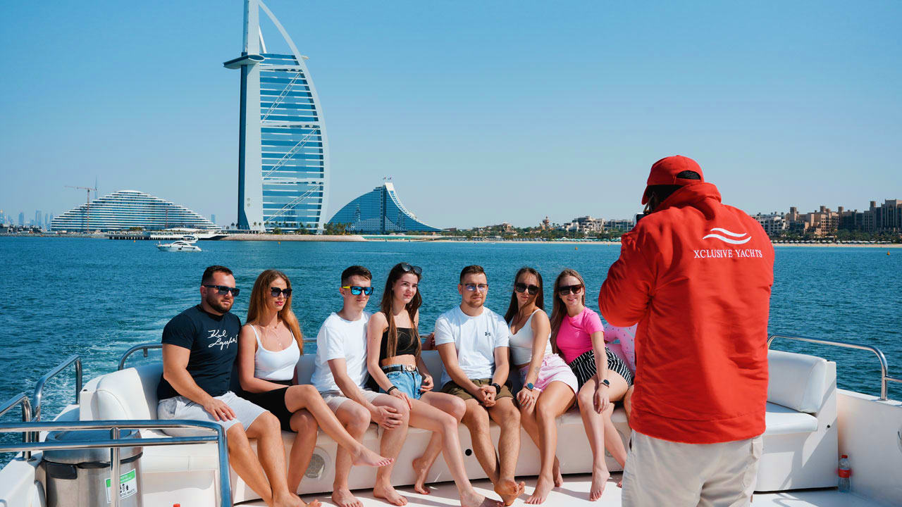 Group of tourists enjoying a shared yacht tour with skyline and water in background (2)
