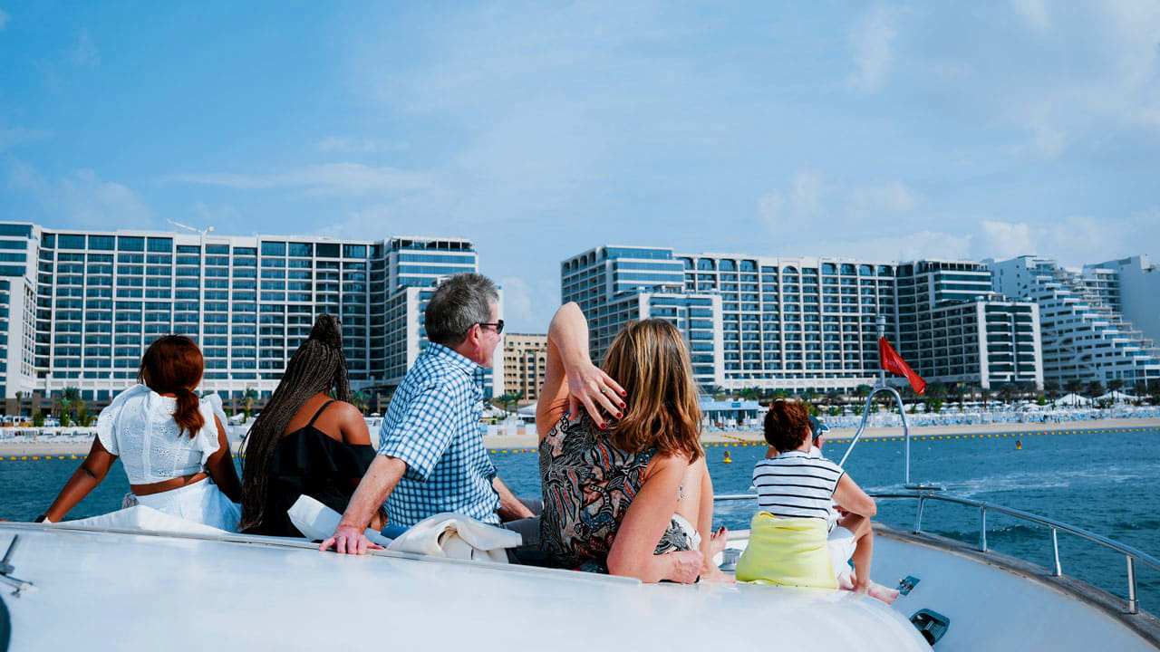 Group of tourists enjoying a shared yacht tour with skyline and water in background (4)