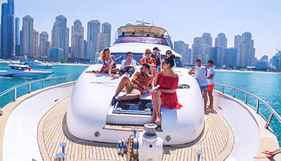 Group of tourists enjoying a shared yacht tour with skyline and water in background