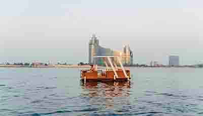 Red floating cafe on Thames River with Tower Bridge visible in the background across London skyline