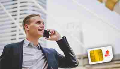 Businessman in suit talking on phone with Etisalat SIM card displayed on desk