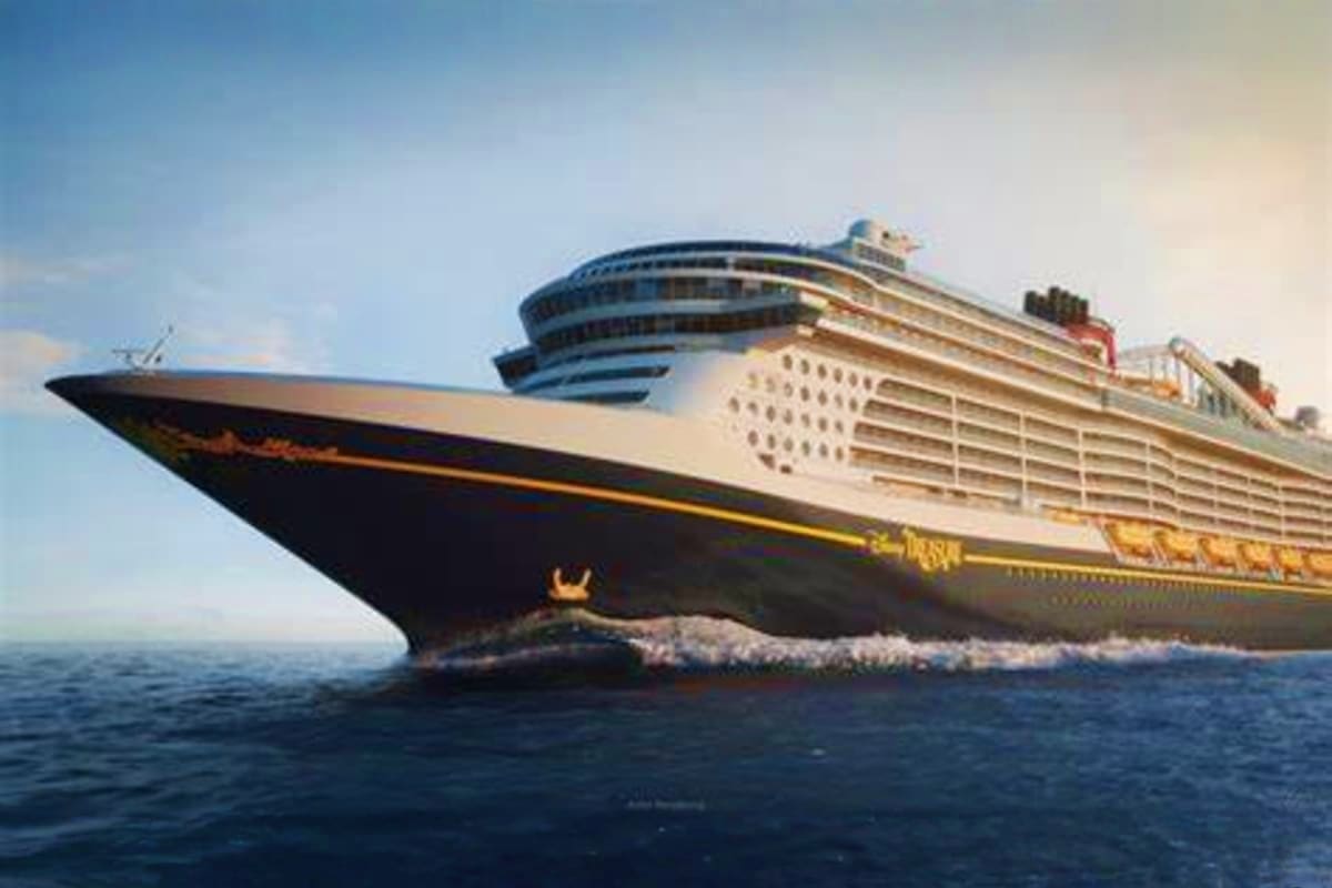 Large modern cruise ship with black hull and white superstructure sailing on blue ocean water under clear sky