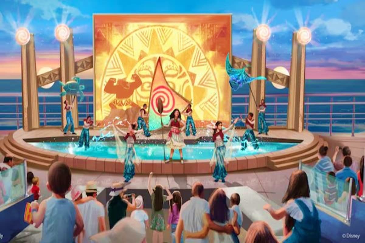 Disney stage performance on cruise ship with dancers in turquoise costumes, golden sun backdrop, and audience watching from d