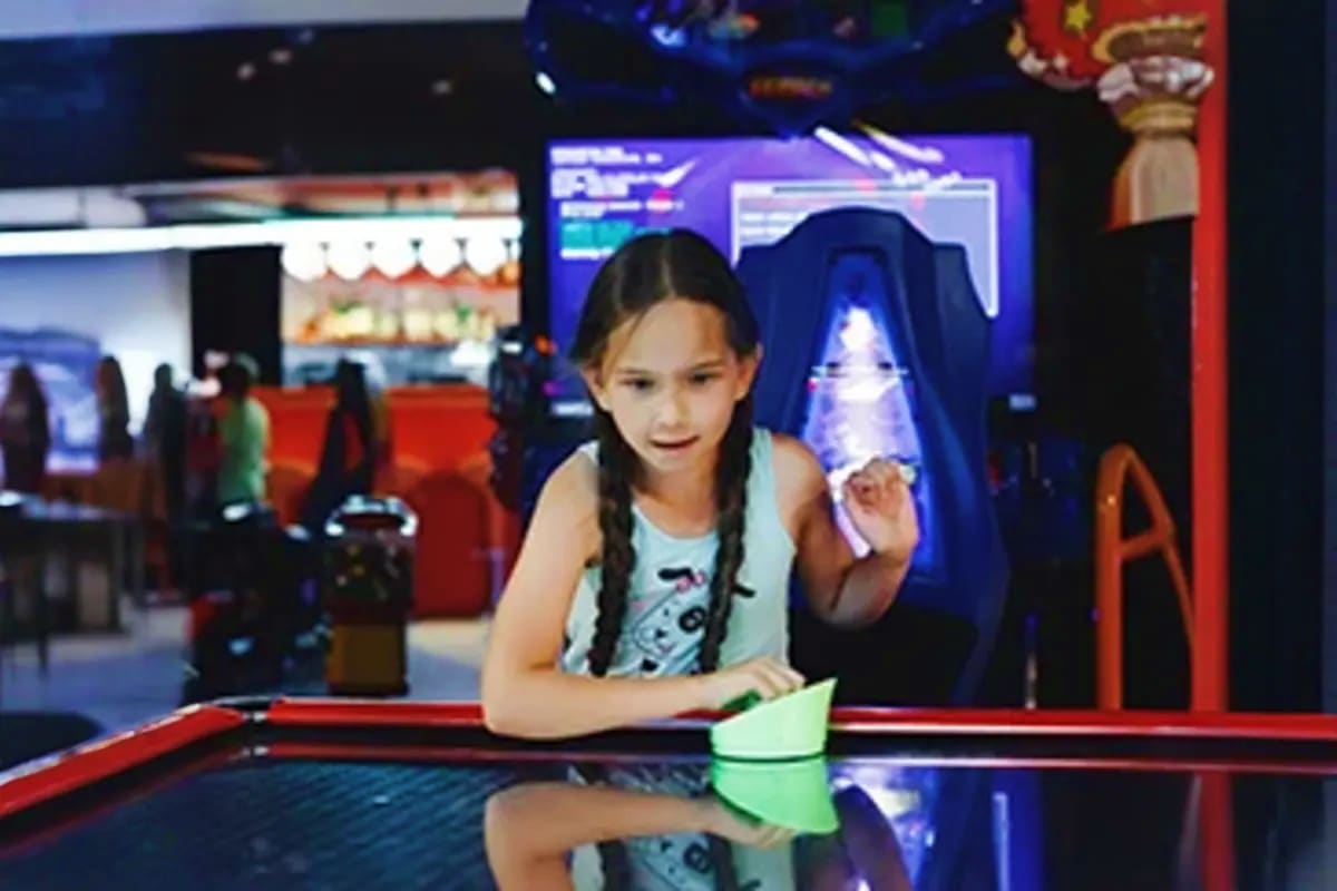 Lakshadweep Island Cruise Child playing with interactive holographic display at indoor arcade entertainment venue on cruise ship
