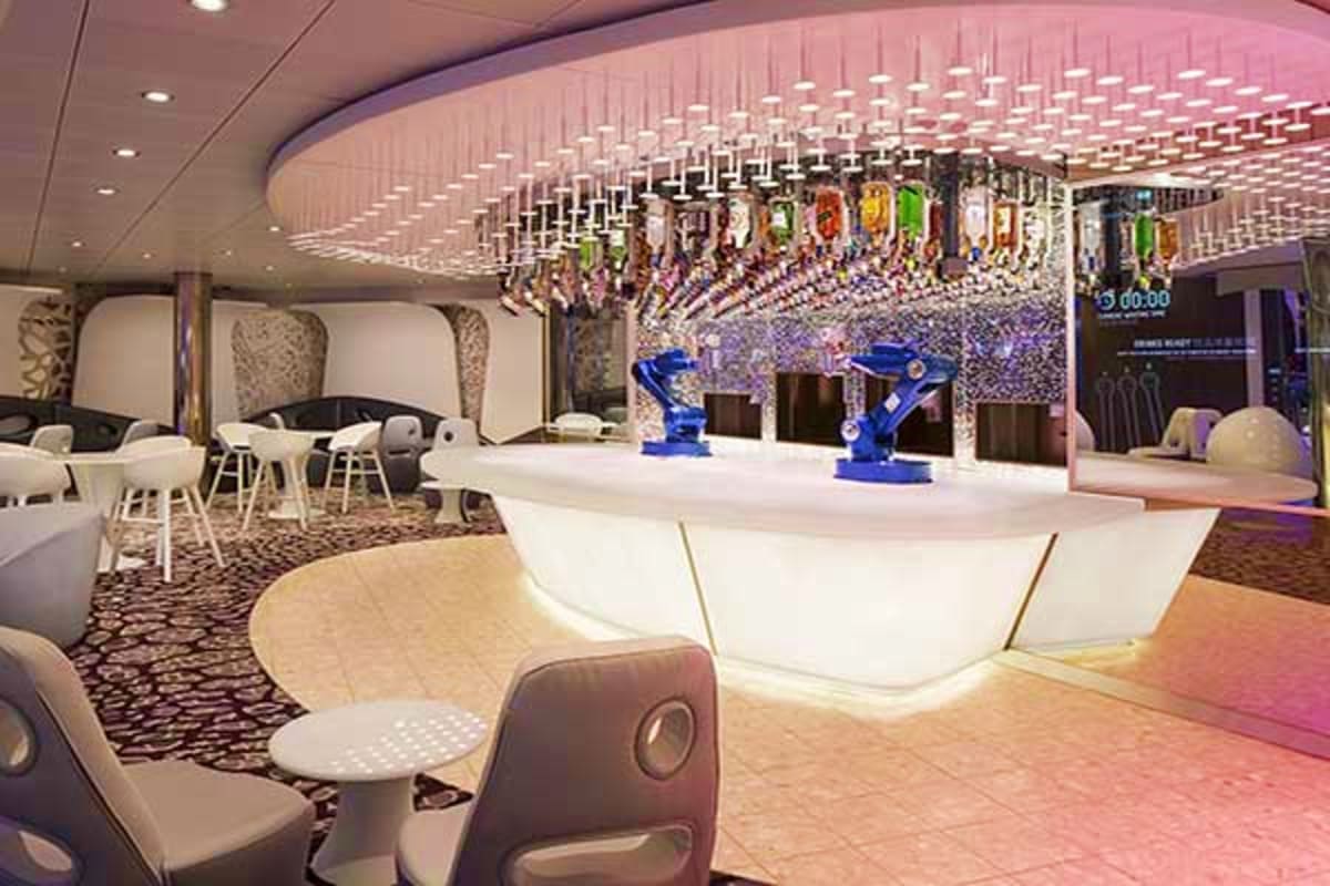 Modern cruise ship lounge with curved white reception desk, blue robotic displays, illuminated ceiling with hanging decorativ