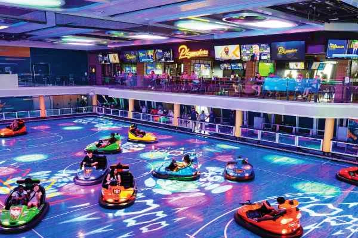 Spectrum of the Seas Shanghai Escape Indoor bumper car arena with colorful illuminated floor and multiple levels of viewing areas on a cruise ship