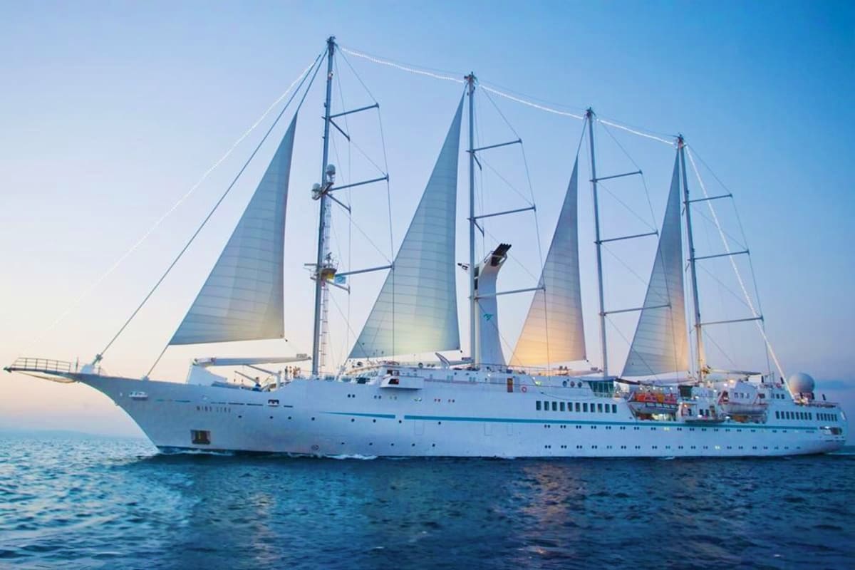 Wind Star Greek Isles Treasures White luxury sailing cruise ship Wind Star with four tall masts and billowing sails on blue Mediterranean Sea