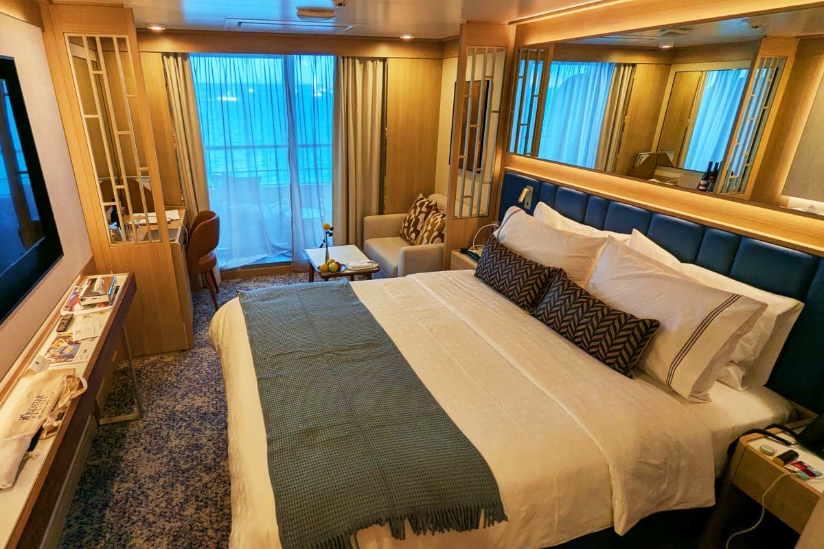 Wind Star Greek Isles Treasures Luxury cruise ship stateroom with king bed, wood furnishings, large windows overlooking ocean, seating area, and modern ameni