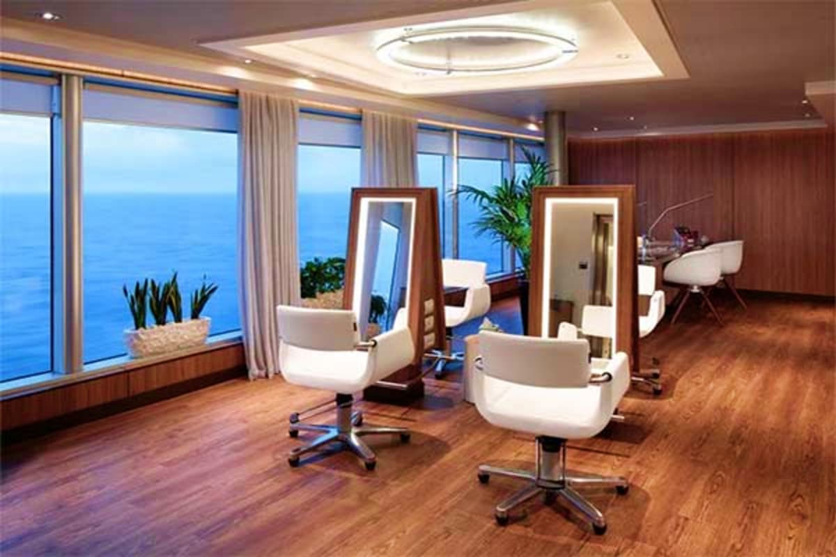 Luxury spa salon on Eurodam cruise ship with ocean views, salon chairs, mirrors, and floor-to-ceiling windows overlooking blu