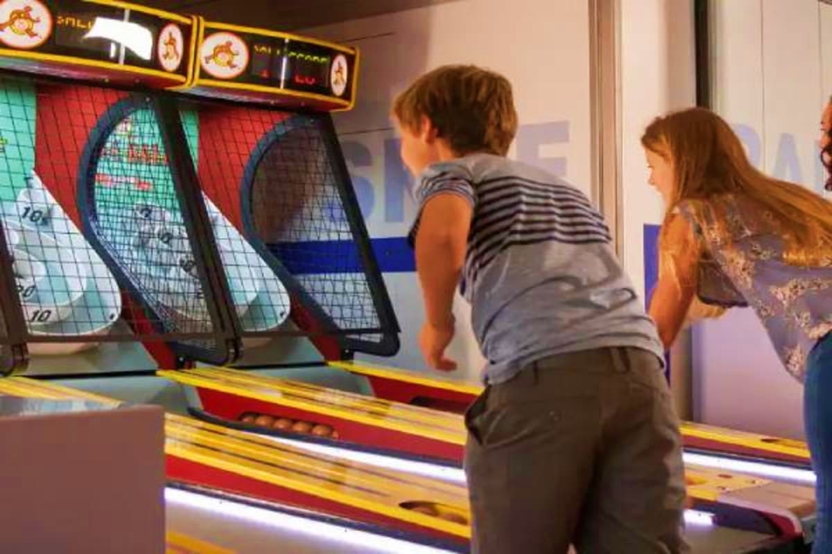 Children playing basketball arcade game with net targets on cruise ship entertainment venue