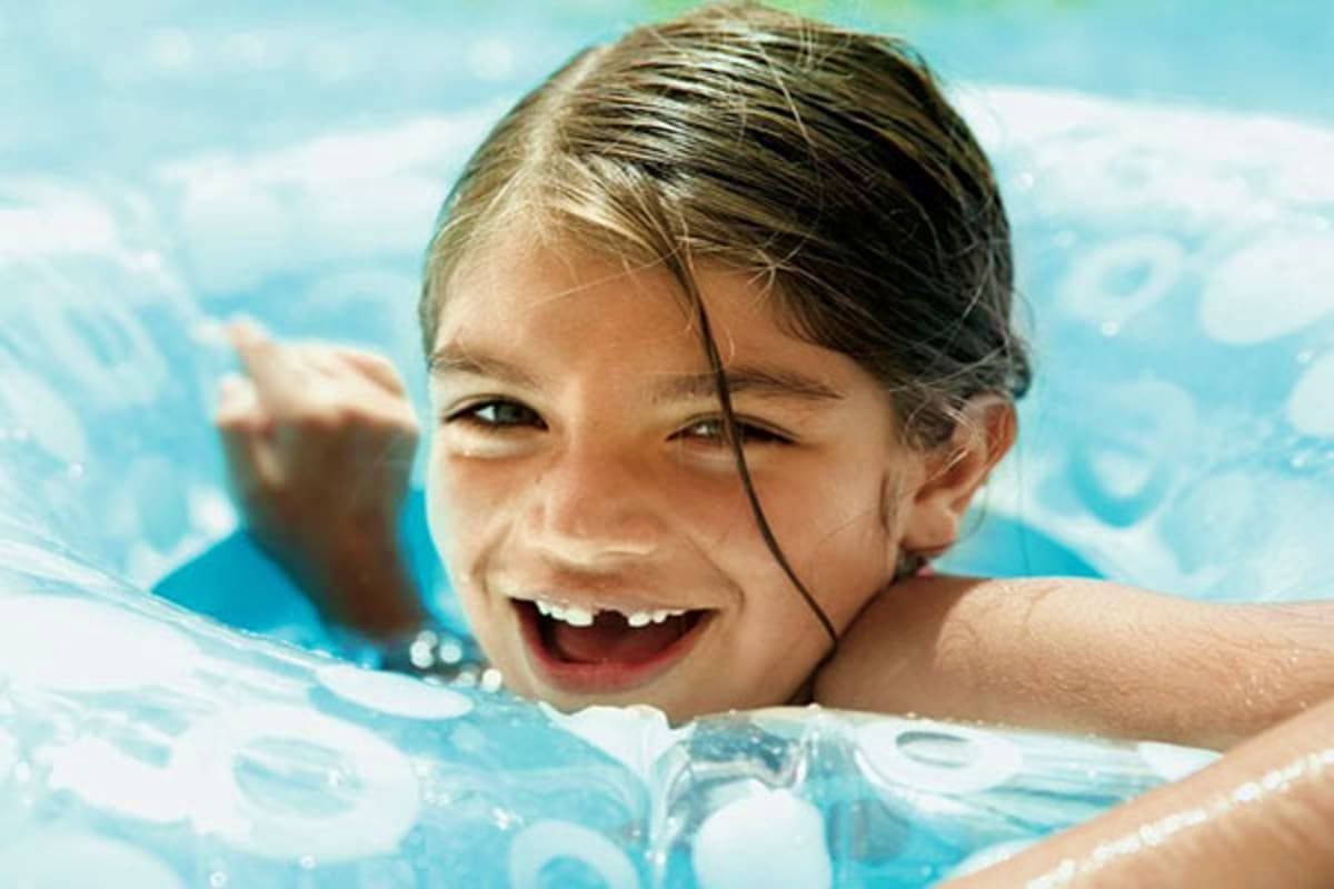 Happy child enjoying swimming in a pool with flotation device during a cruise vacation