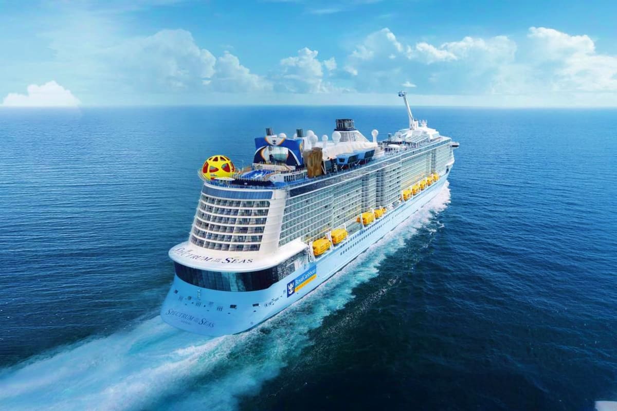Spectrum of the Seas cruise ship sailing on clear blue ocean waters with white clouds in sky