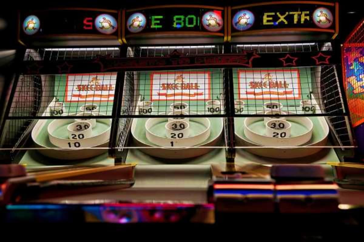 Skee-ball arcade game with three lanes showing scoring targets and point values at an arcade or game room venue