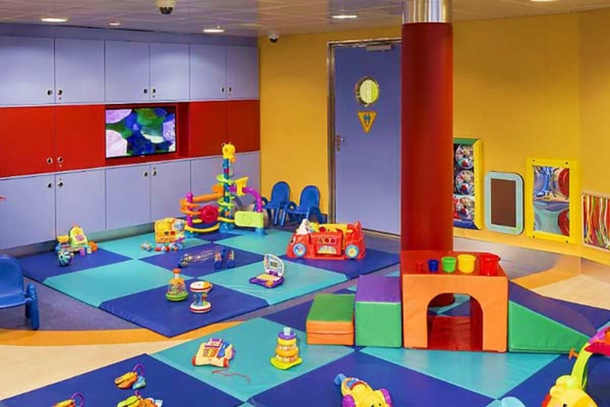 Colorful indoor play area for toddlers with soft foam blocks, toys, and padded floor in bright primary colors