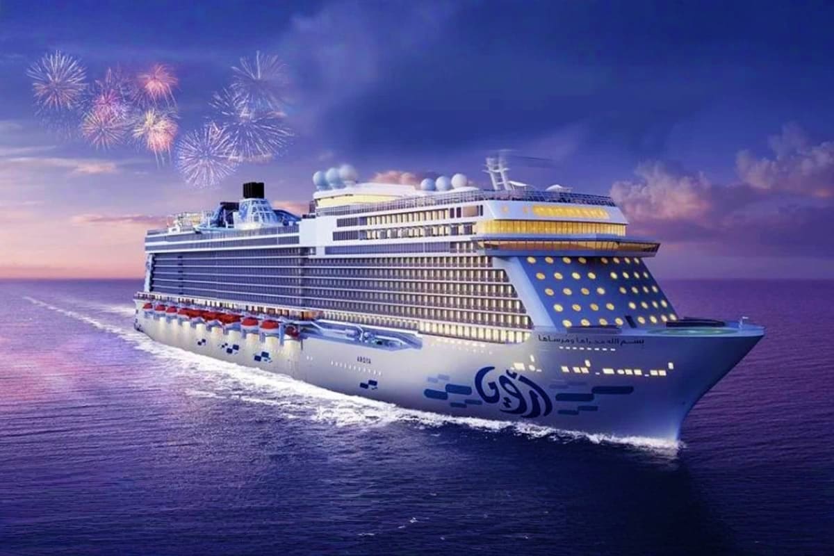 Luxury cruise ship with GSD branding sailing on blue ocean waters at sunset with fireworks display in purple sky