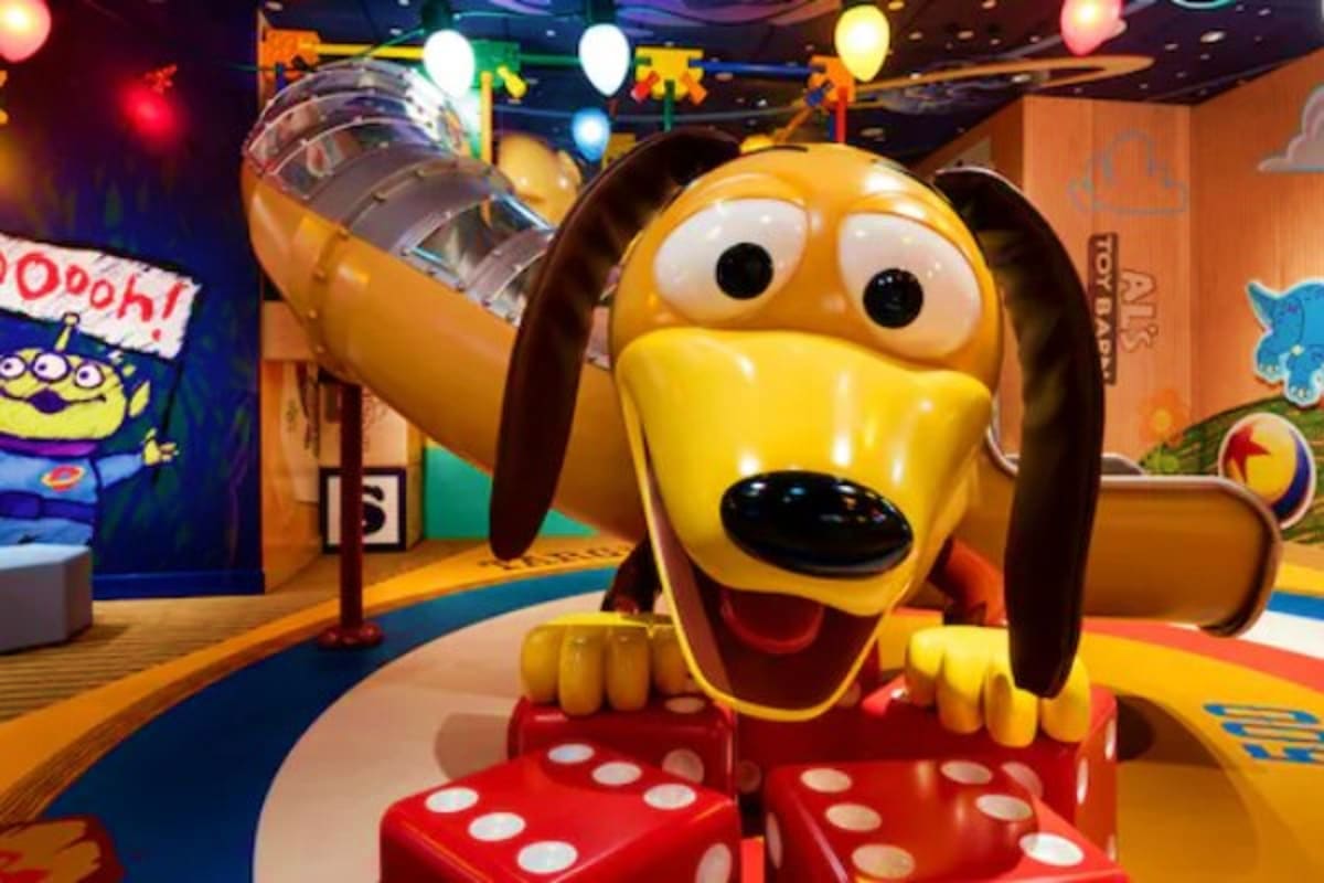 Colorful toy story themed character display with yellow dog figure and large red dice in family entertainment area