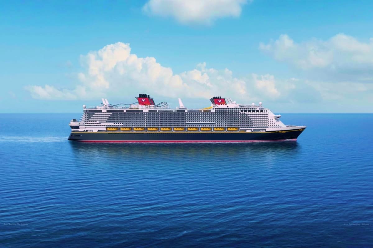Four Nights Disney Island Escape Large white cruise ship with red funnels sailing on calm blue ocean under clear sky with white clouds
