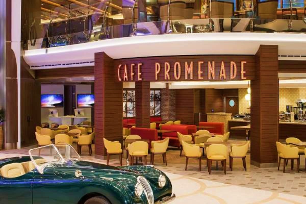 Asian Horizons Cruise Cafe Promenade on Asian Horizons Cruise with yellow chairs, red seating, and a vintage green sports car display