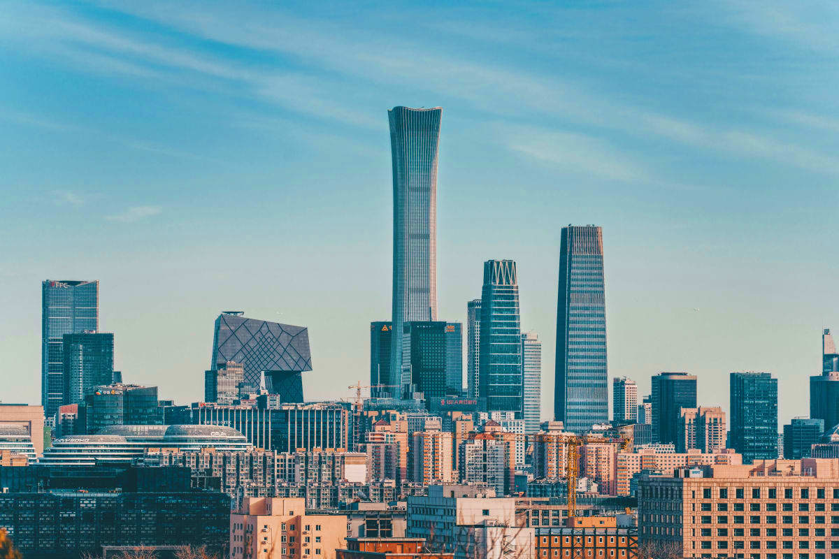Beijing skyline featuring tall modern skyscrapers and residential buildings against a clear blue sky